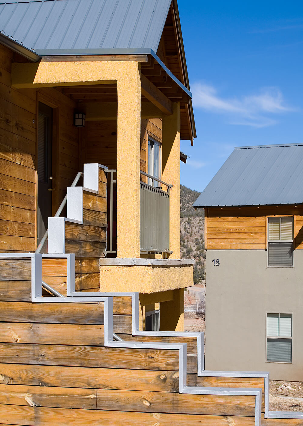 Stepped timber walls and a covered entry on a two-story home at Ladera in Ruidoso Downs, New Mexico