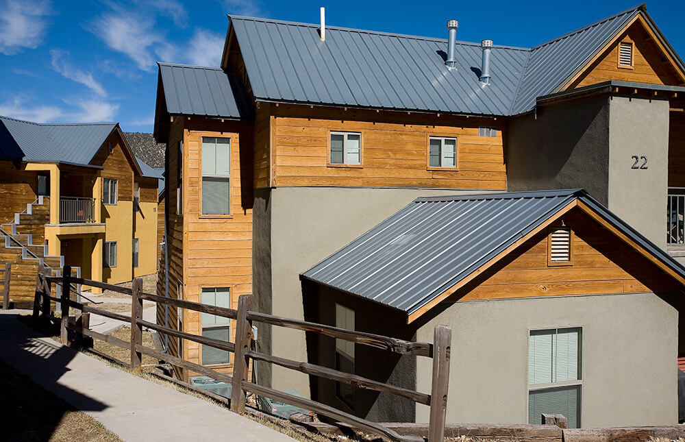 Two-story building with timber siding behind a wooden rail fence at Ladera